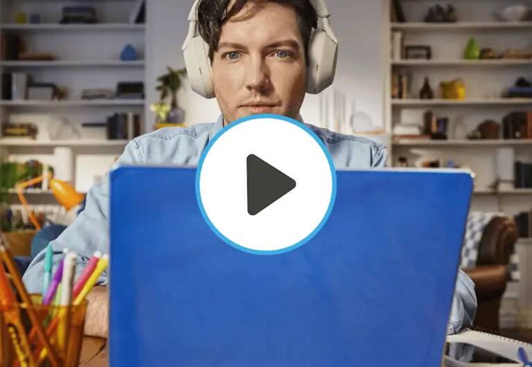 Man looks down at his laptop in a home workspace with the word work superimposed over him.